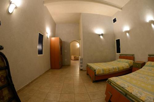 a hotel room with two beds and a hallway at Bauhaus Motel in Bcharré