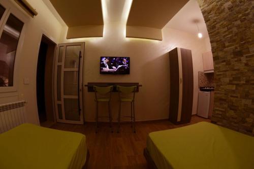 a room with two beds and a tv on the wall at Bauhaus Motel in Bcharré