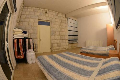 a bedroom with two beds and a stone wall at Bauhaus Motel in Bcharré