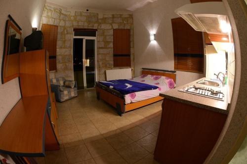 a bedroom with a bed and a kitchen with a sink at Bauhaus Motel in Bcharré