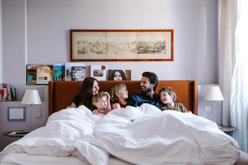 Eine Familie liegt im Bett mit in der Unterkunft Boutique Hotel Auersperg in Salzburg