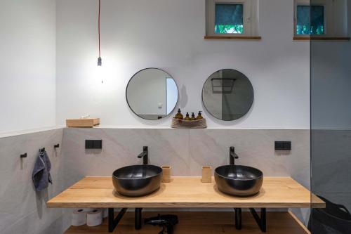 two sinks on a wooden counter with two mirrors at Apartment am Grundlsee in Grundlsee
