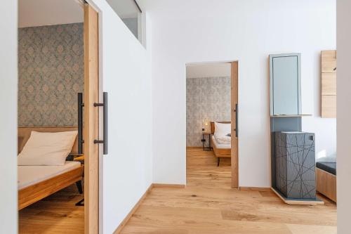 a bedroom with a bed and a door leading into a room at Apartment am Grundlsee - Your Austrian Home in Grundlsee
