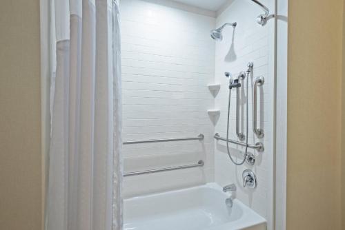 baño blanco con ducha y lavamanos en Holiday Inn Express & Suites New Cumberland, an IHG Hotel en New Cumberland