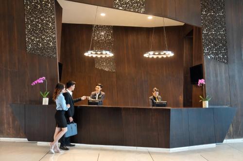 a group of people standing at a reception desk at Novotel Lampung in Bandar Lampung