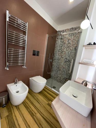 La salle de bains est pourvue de toilettes, d'un lavabo et d'une douche. dans l'établissement BB4U Apartments al Massimo, à Palerme