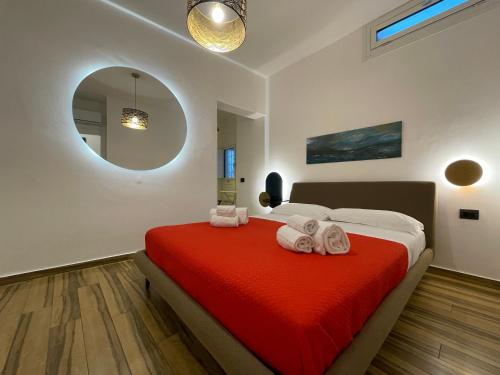 - une chambre avec un lit doté d'une couverture rouge et d'un miroir dans l'établissement BB4U Apartments al Massimo, à Palerme