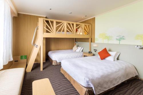 two beds in a room with a bunk bed at Kichijoji Excel Hotel Tokyu in Musashino