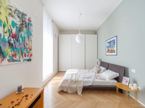 sypialnia z łóżkiem i obrazem na ścianie w obiekcie The Best Rent - Spacious three-bedroom apartment with terrace w Mediolanie