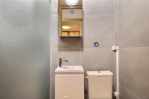 une salle de bain avec toilettes, lavabo et miroir dans l'établissement Residence Saulire, à Méribel