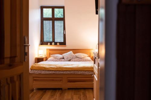 a bedroom with a bed with two pillows and a window at SPA Pod Javory in Nejdek