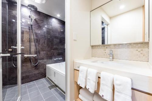a bathroom with a shower and a sink at Kichijoji Excel Hotel Tokyu in Musashino
