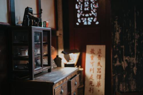 a room with a wooden dresser with a lamp on it at 島中大厝 in Jinhu