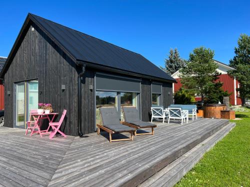 a large wooden deck with chairs and a table at Soda Home - The Tiny House - 24h check in in Närpiö