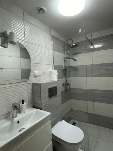 W łazience znajduje się prysznic, toaleta i umywalka. w obiekcie Dom Gościnny w mieście Mikołajki