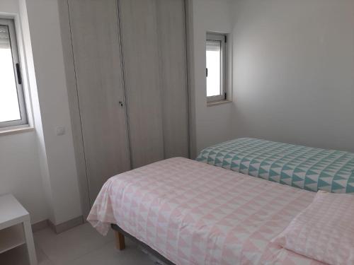 a small bedroom with two beds and a window at Vue Ocean in Portimão
