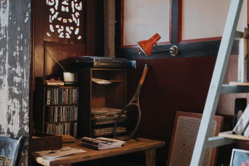 una stanza con un tavolo con libri e una lampada di 島中大厝 a Jinhu