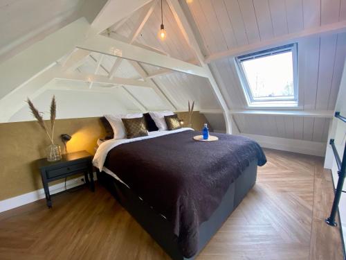 ein Schlafzimmer mit einem großen Bett im Dachgeschoss in der Unterkunft Kerkje van Peins in Peins