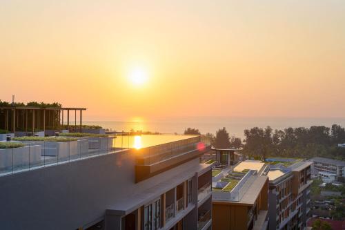 スリンビーチにあるMida Grande Resort Phuket Official Accountの建物から見える夕日の景色