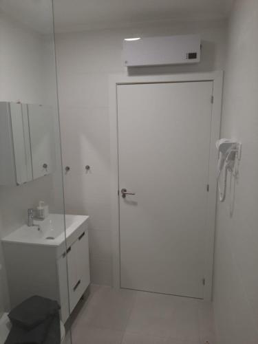 a white bathroom with a shower and a sink at Vue Ocean in Portimão