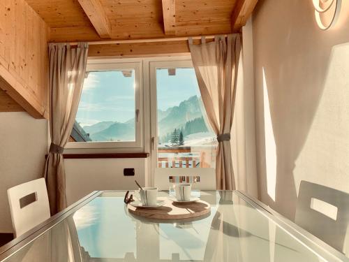 a glass table in a room with a window at Eurochalet in Campitello di Fassa