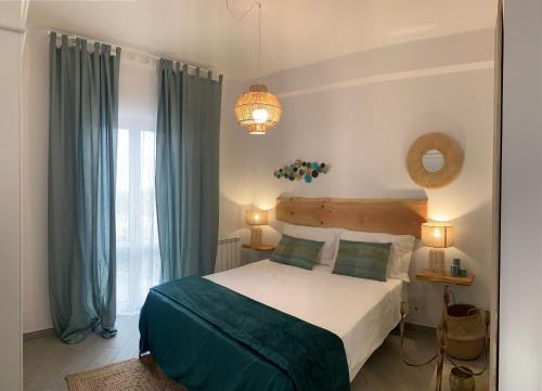 1 dormitorio con 1 cama grande y cortinas azules en Il Fiore Bianco, en Capo dʼOrlando