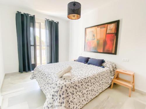 奇克拉納－德拉弗龍特拉的住宿－Apartamento Sol y Sal，一间卧室配有一张带蓝色枕头的大床