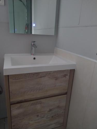 a bathroom with a white sink and a mirror at Chez Pascal et Claudia in Kumak