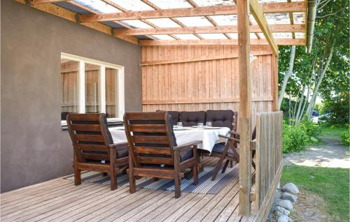 a patio with a table and chairs on a deck at 2 Bedroom Amazing Home In Fjälkinge in Fjälkinge