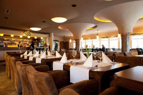 ビストシツァ・クウォツカにあるHotel i Restauracja ABISのテーブルと椅子、背景の人々が並ぶレストラン