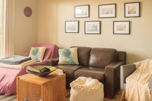 a living room with a brown couch and a table at The views!Lovely apartment on acreage with magnificent views, dog friendly in Panton Hill