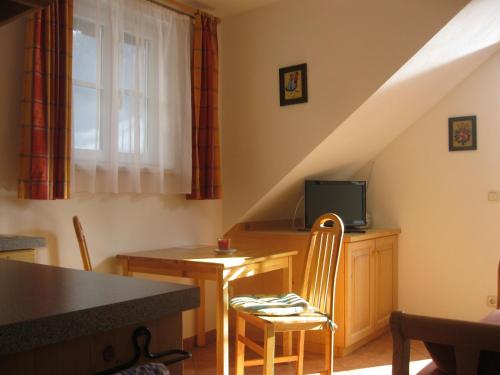 ein Wohnzimmer mit einem Tisch, Stühlen und einer Treppe in der Unterkunft Pension Sarstein in Hallstatt