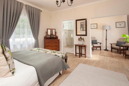 a bedroom with two beds and a living room at Cliff Cottage Hermanus in Hermanus