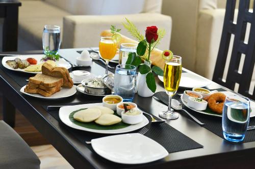 a table with plates of food and glasses of wine at Ethnotel, Kolkata Airport in Kolkata