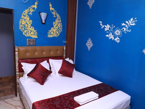 a blue bedroom with a bed with red pillows at Hotel Sas Royal Galaxy By WB Inn in Yelahanka