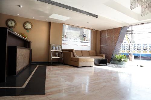 a living room with a couch and a tv at Ethnotel, Kolkata Airport in Kolkata
