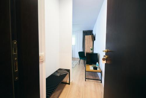 a hallway with a door and a room with a chair at Residence Villa Barrio in Bucharest