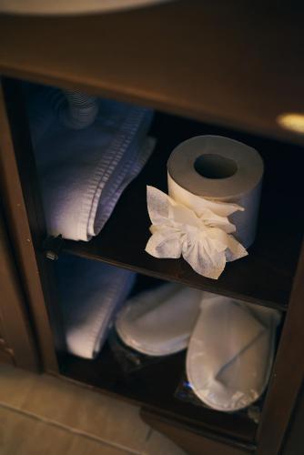 a shelf with a roll of toilet paper and towels at Residence Villa Barrio in Bucharest