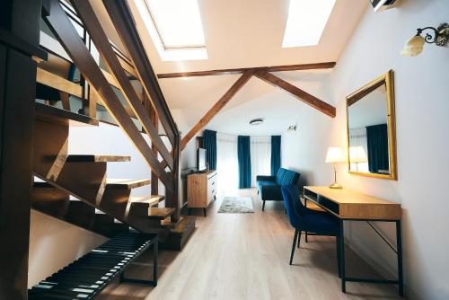 a room with a staircase and a desk and chairs at Residence Villa Barrio in Bucharest