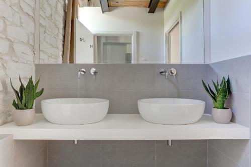 two sinks in a bathroom with plants on a counter at Villa Vetta Marina - My Extra Home in Sirolo