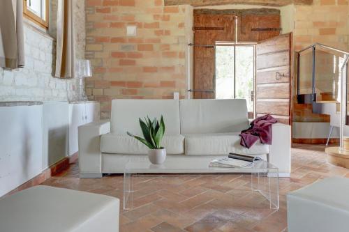 Villa Vetta Marina - My Extra Home في سيرولو: غرفة معيشة مع أريكة بيضاء وطاولة