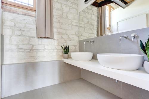 2 umywalki w łazience z kamienną ścianą w obiekcie Villa Vetta Marina - My Extra Home w mieście Sirolo