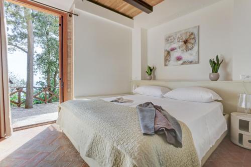 een slaapkamer met een bed en een groot raam bij Villa Vetta Marina - My Extra Home in Sirolo