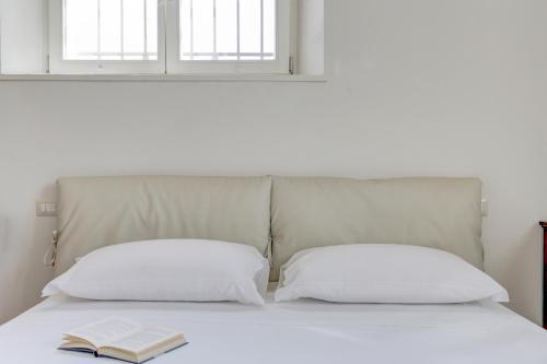 a bed with two pillows and a book on it at Villa Vetta Marina - My Extra Home in Sirolo