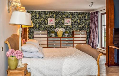 sypialnia z łóżkiem z lampą i kwiatami w obiekcie 3 Bedroom Amazing Home In Golczewo w mieście Golczewo