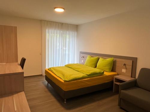 ein Schlafzimmer mit einem Bett mit gelben Kissen in der Unterkunft Motel Afia in Cama