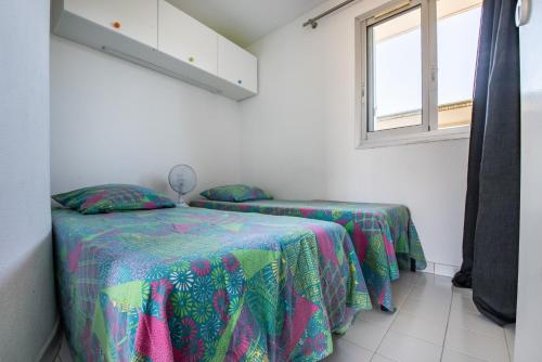 une chambre avec deux lits et une fenêtre dans l'établissement La Dunette, à La Grande Motte