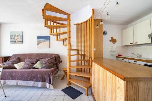 un salon avec un escalier en colimaçon et une cuisine dans l'établissement La Dunette, à La Grande Motte