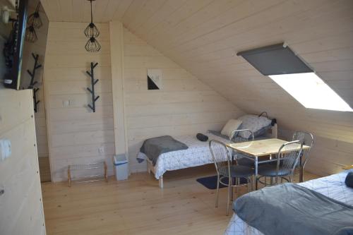 a room with a bed and a table in a attic at Noclegi Święta Katarzyna ,, Pod Jeleniami "prawdziwymi in Święta Katarzyna
