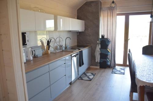 a kitchen with white cabinets and a wooden floor at Noclegi Święta Katarzyna ,, Pod Jeleniami "prawdziwymi in Święta Katarzyna